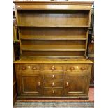 AN ANGLESEY OAK AND PINE DRESSER, mid 19th Century, shaped three plate rack with wide back boards on