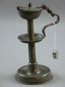 A PEWTER TALLOW LAMP, a circular based pewter tallow lamp, the turned column having a centre dish