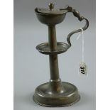 A PEWTER TALLOW LAMP, a circular based pewter tallow lamp, the turned column having a centre dish