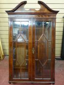 A MAHOGANY TWO DOOR WALL MOUNTED DISPLAY CABINET of quality reproduction with broken pediment,