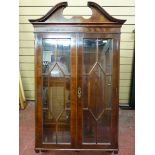 A MAHOGANY TWO DOOR WALL MOUNTED DISPLAY CABINET of quality reproduction with broken pediment,