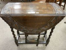 A NEAT CARVED OAK BARLEY TWIST GATE LEG TABLE, 66 cms high, 64.5 cms wide, 29 cms deep closed