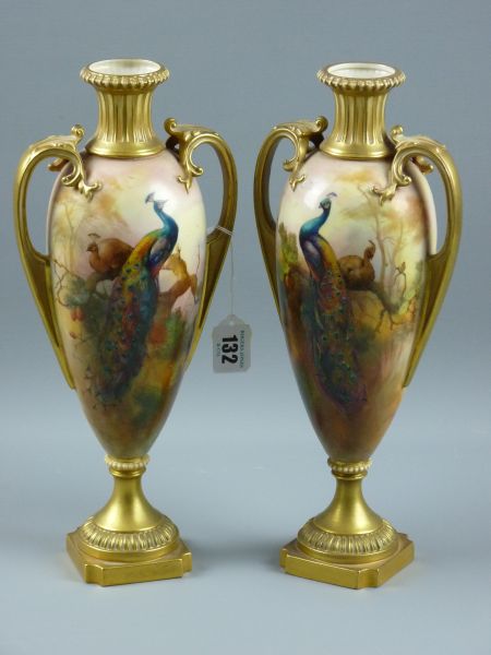 A PAIR OF ROYAL WORCESTER TWIN HANDLED VASES, decorated with opposing hand painted peacocks and hens