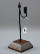 AN 18TH CENTURY RUSH LIGHT HOLDER, 32 cms tall iron rush nip with sconce counterweight in a slightly