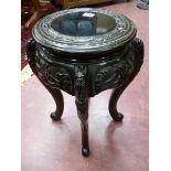 AN ORIENTAL CARVED WOOD STAND, a circular top with carved frieze and shaped legs, 45 cms high, 26