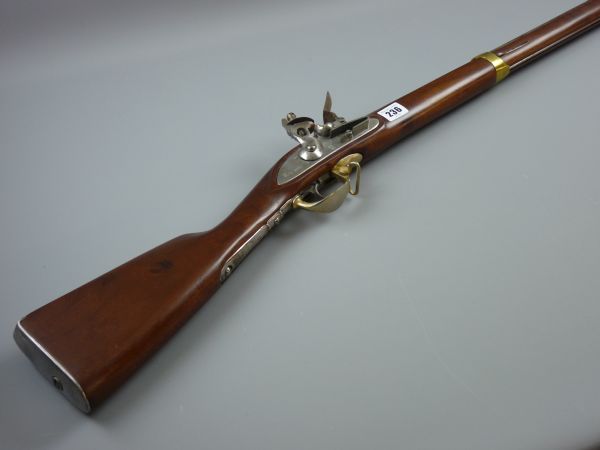 A REPLICA FLINTLOCK MUSKET with walnut stock, polished steel and brass fittings, the lock plate