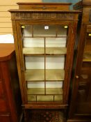 AN OAK DISPLAY CABINET, 1930's with railback single glazed door and fixed interior shelves on barley