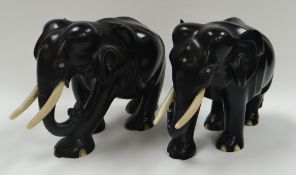 A PAIR OF EBONY ELEPHANTS, in walking position and with ivory tusks, 22cms long