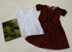 A YOUNG GIRL'S WELSH FOLK DRESS in plaid with black felt trim and buttons together with a linen