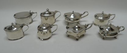 EIGHT SILVER MUSTARD POTS WITH HINGED LIDS of various shape and form, 12.8ozs