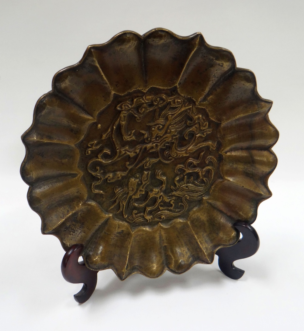 A CHINESE BRONZE ARCHAIC DISH decorated in relief with a centre dragon motif and with a fanned