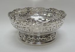 A SILVER BOWL of circular footed form and with all-round open-work decoration and crimped rim, 18cms