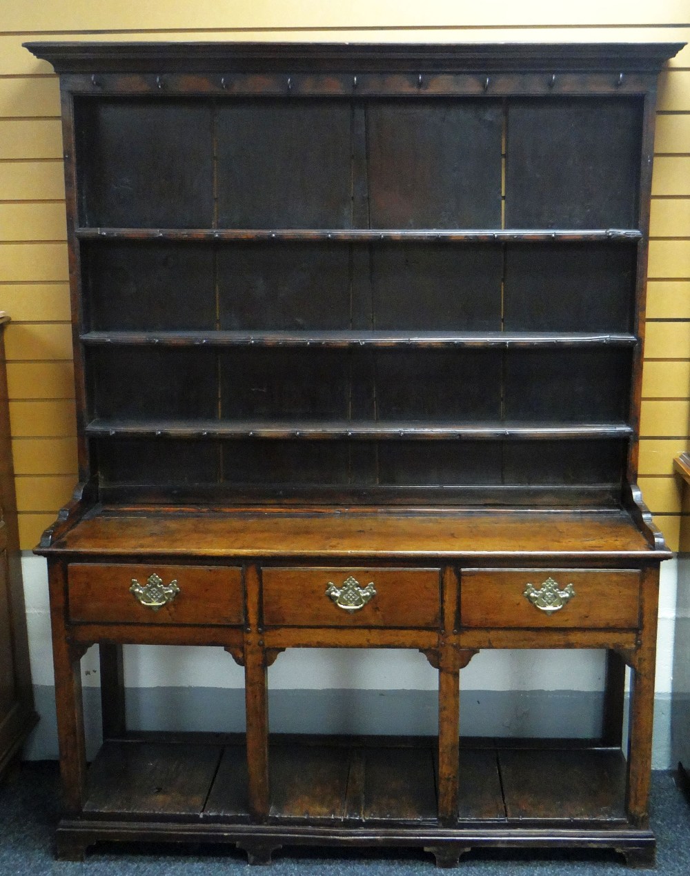 A SMALL NINETEENTH CENTURY WEST WALES OAK DRESSER having a base of three drawers, with brass handles