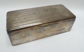 A SILVER CIGARETTE BOX of rounded rectangular form with machine-turned hinged lid and monogram,