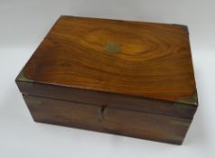 A CAMPAIGN STYLE LAP DESK with brass mounts and tooled leather interior, 30cms wide