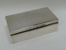 A SILVER CIGARETTE BOX with military inscription to the lid (Capt F Le Feuvre), 18cms long