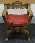 A CARVED OAK HERALDIC X-CHAIR with medallion back bearing shield and crown and with carved rosettes