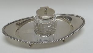 A SILVER OVAL INKSTAND with feathered border and single inkwell, Birmingham 1900, 3.3ozs