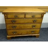 A REPRODUCTION OAK CHEST OF DRAWERS on bracket feet with three long drawers and two short and having