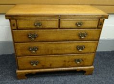 A REPRODUCTION OAK CHEST OF DRAWERS on bracket feet with three long drawers and two short and having