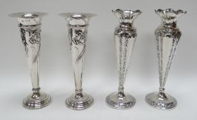 TWO PAIRS OF SILVER ROSE VASES on circular bases of tapered form with raised decoration