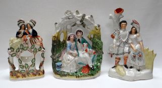 THREE NINETEENTH CENTURY STAFFORDSHIRE MODELS comprising a seated courting couple with dog beneath a