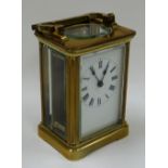 A BEVELLED GLASS CARRIAGE CLOCK bearing Roman numerals to the rectangular white dial (key with