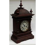 A BLACK-FOREST MANTEL CLOCK BY JUNGHANS with carved dome top, circular dial bearing Roman