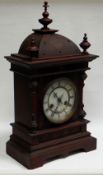 A BLACK-FOREST MANTEL CLOCK BY JUNGHANS with carved dome top, circular dial bearing Roman