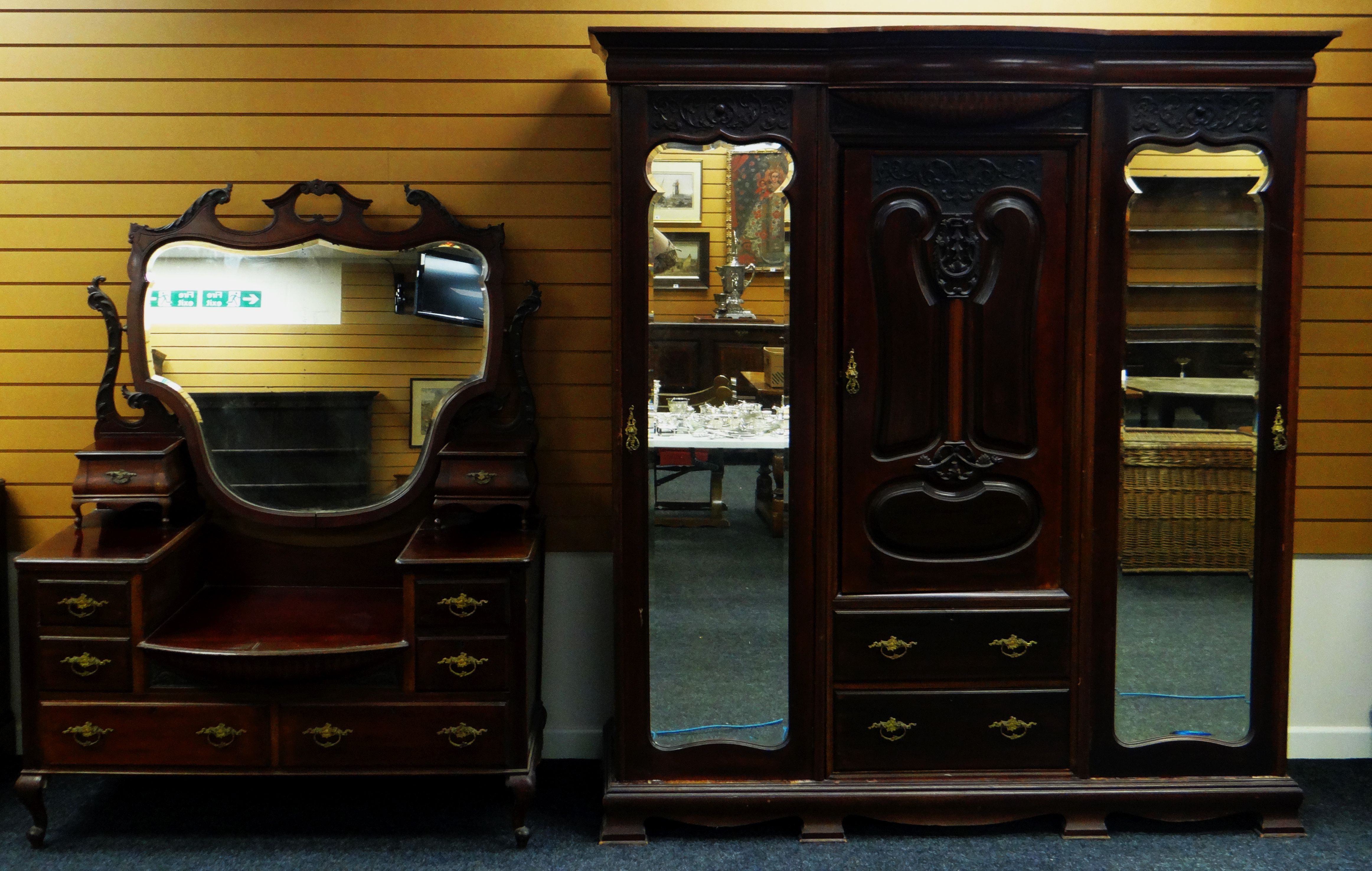 AN EDWARDIAN MAHOGANY PART BEDROOM SUITE comprising ornate carved triple wardrobe, 181cms wid