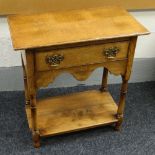 A REPRODUCTION OAK LOW-BOY having a lower plank shelf and with single drawer above, 66cms wide