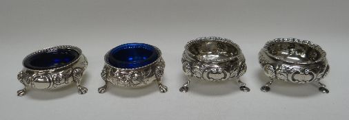 TWO PAIRS OF SIMILAR SILVER SALTS, both pairs with repoussé work and on pad or claw feet, 8.4ozs