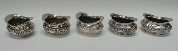 A SET OF FIVE SILVER SALTS with relief decoration, 4.5ozs