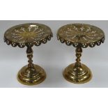 A PAIR OF BRASS KETTLE STANDS on circular bases with pierce and apron-decorated tops, 26cms high