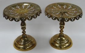 A PAIR OF BRASS KETTLE STANDS on circular bases with pierce and apron-decorated tops, 26cms high