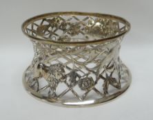 AN IRISH SILVER DISH RING of spool shape and of open lattice-work form decorated with embossed
