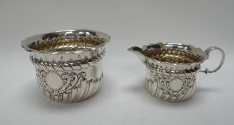 A SILVER SUGAR BASIN & MATCHING CREAM JUG both with repoussé decoration and cartouche, Birmingham