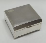 A SQUARE SILVER CIGARETTE BOX with machine turned decoration on bracket-feet, Chester 1938, 8.