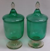 A PAIR OF GREEN & CLEAR GLASS APOTHECARY JARS with lids and pointed clear glass knops, 38cms high