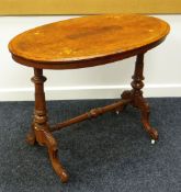 AN INLAID WALNUT OVAL OCCASIONAL TABLE on turned supports and carved scroll feet, 90cms long