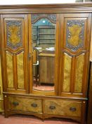 A LATE VICTORIAN CARVED WALNUT WARDROBE with inverted stepped crown over a central mirrored door,