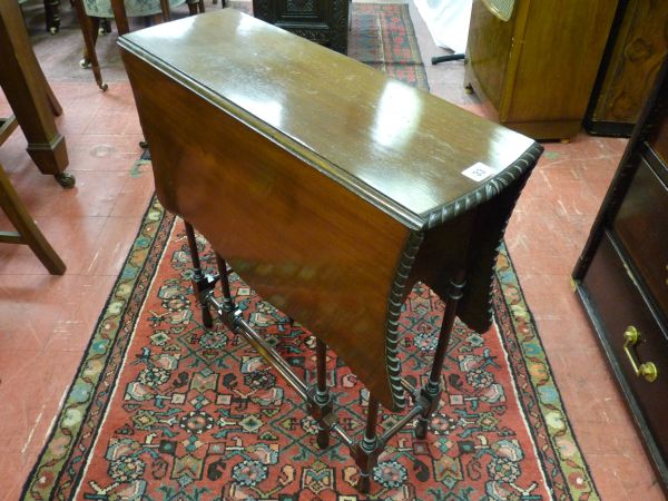 A CIRCA 1900 SPIDER LEG TABLE with slim rectangular top and shaped drop leaves, decorative side