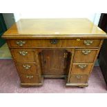 A GEORGE III & LATER WALNUT KNEEHOLE WRITING DESK having a rectangular top with line inlay over a