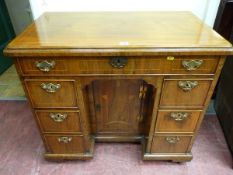 A GEORGE III & LATER WALNUT KNEEHOLE WRITING DESK having a rectangular top with line inlay over a