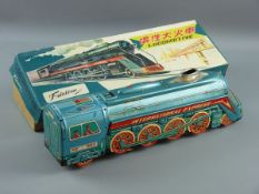 A TINPLATE FRICTION DRIVE LOCOMOTIVE, FM-804 International Express in brightly coloured livery,