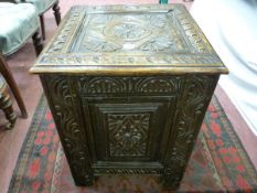 A CARVED OAK LOG BOX, near square with deep Jacobean style decoration and iron carry handles on