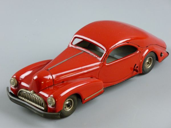 A RED TINPLATE CLOCKWORK CAR, sloping back sports model with side brake and steer adjuster,