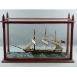 A CASED SHIP, the triplemaster 'Dora' depicted in heavy seas, in a pine case with glass panels all
