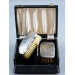 A BOXED PAIR OF GENT'S SILVER BACK HAIRBRUSHES with comb, Birmingham 1990