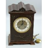 A CIRCA 1900 CARVED MAHOGANY MANTEL CLOCK, the shaped top case with leaf and floral front decoration